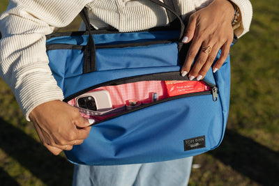 visible lifestyle^^A Nomad Tote with its front pocket open.