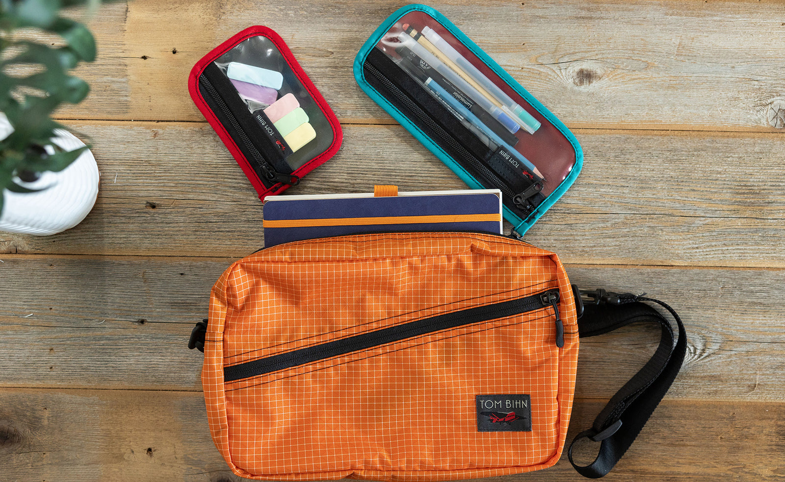 visible lifestyle^^A Packing Cube Shoulder Bag with two mystery pouches and a notepad.