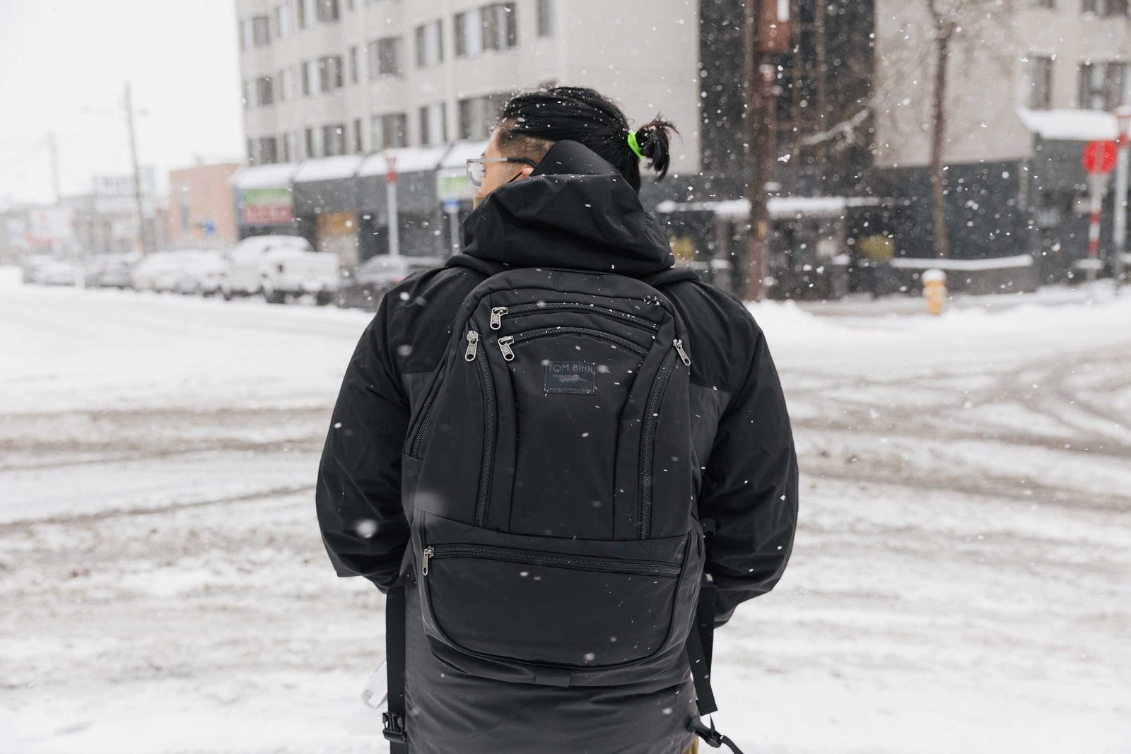 Person walking in the snow in Seattle, carrying a Synapse 25 in Black.