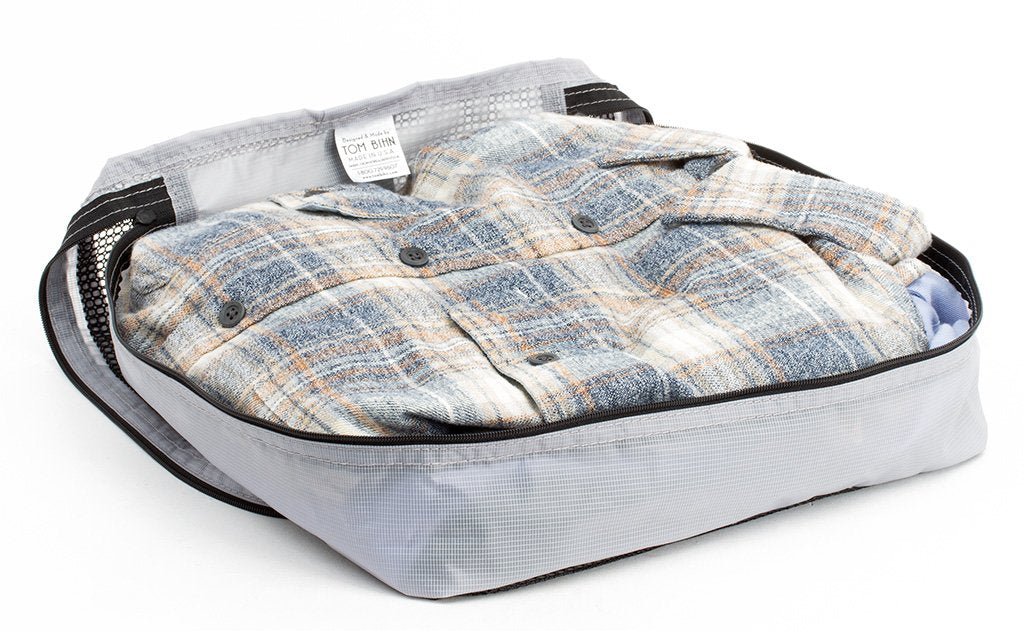 visible variant TB90504-NE^^A few button-down shirts folded in an open Northwest Sky (light grey) Aether Aeronaut 30 Large Packing Cube.