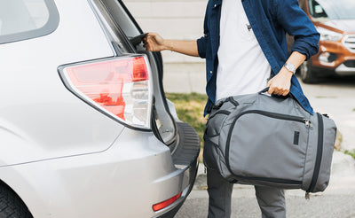 visible lifestyle^^ A person loading a Techonaut 45 into a car using the grab handle.