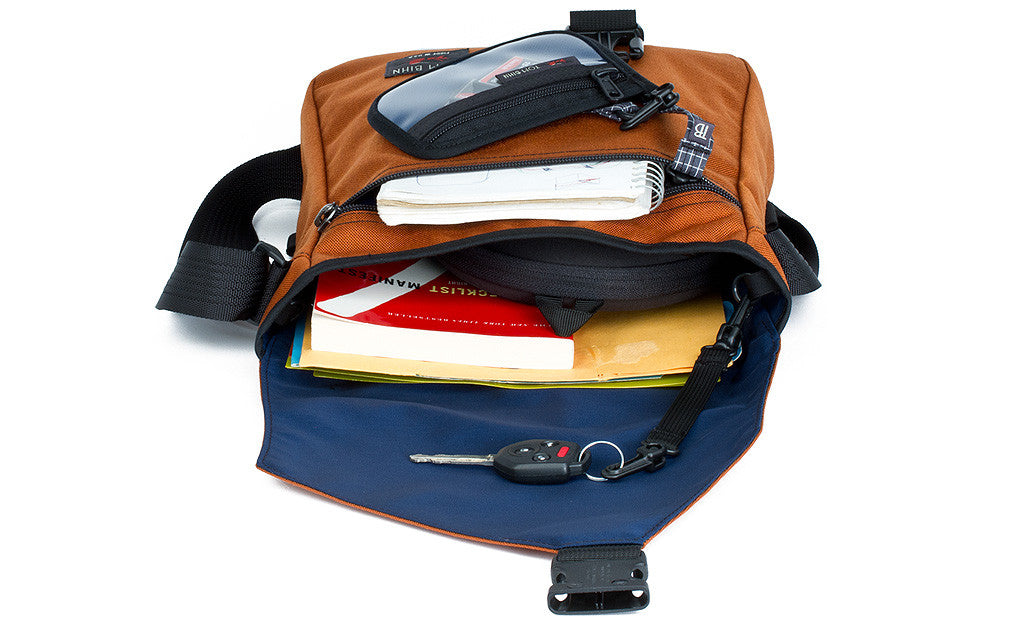 ^^A shot of the main compartment of the Medium Cafe Bag with books, a scarf, and a key fob.