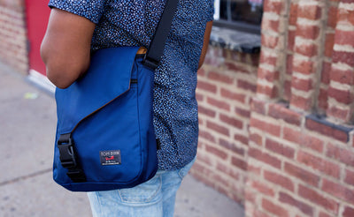 A behind shot of a person walking with the Medium Cafe Bag