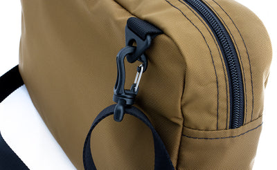 ^^A close shot of the Packing Cube Shoulder Bag's d-ring strap attachment point with a 1" shoulder strap attached.