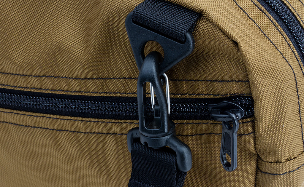 ^^A close shot of the Packing Cube Shoulder Bag's d-ring strap attachment point with a 1" shoulder strap attached.