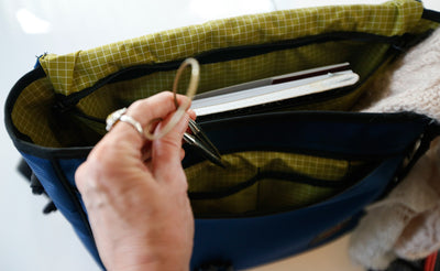 ^^A person pulling a set of cable knitting needles from their Maker's Bag.