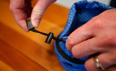 ^^A person tightening the cord of a Travel Tray.