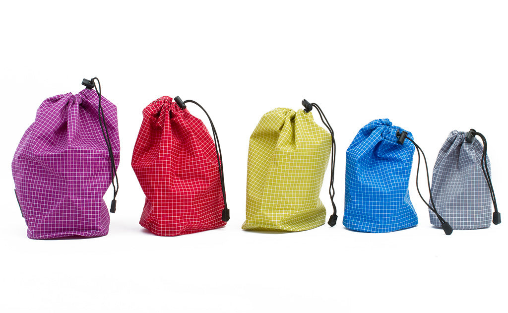 detail visible^^Each size of Travel Stuff Sack cinched closed and placed in a line from largest to smallest.