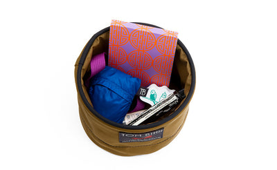 visible detail^^A Small Travel Tray holding a pack of cards, tube of hand-cream, chapstick, pocket travel pillow, key strap and keys.