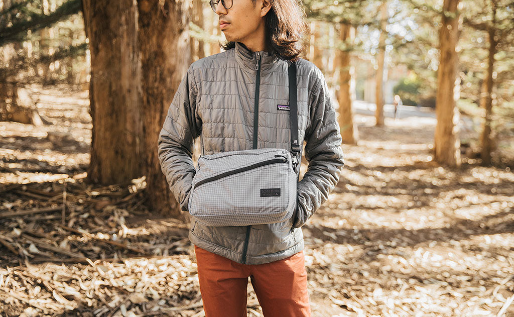 lifestyle visible^^Person wearing the Design Lab Edition Packing Cube Shoulder Bag in Northwest Sky while standing in a forest.
