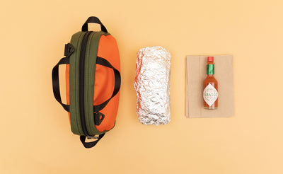 detail visible^^ Texturized Orange Grab Bag next to a foil wrapped burrito and a bottle of Tabasco sauce.