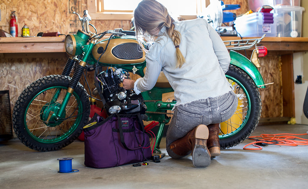 lifestyle visible^^A person working on a motorcycle with The Truck beside them filled with tools.