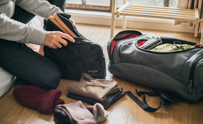 ^^A person packing some thin trainers into a Packing Cube Shoulder Bag.