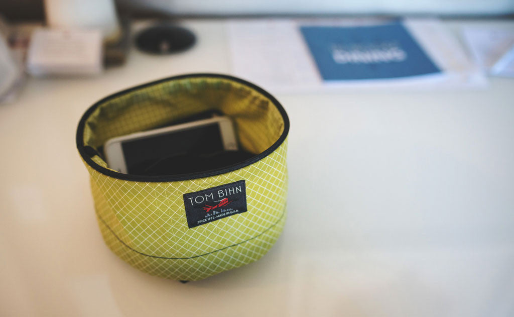 ^^A Small Travel Tray in Wasabi (green) 200 Halcyon holding an iPhone.