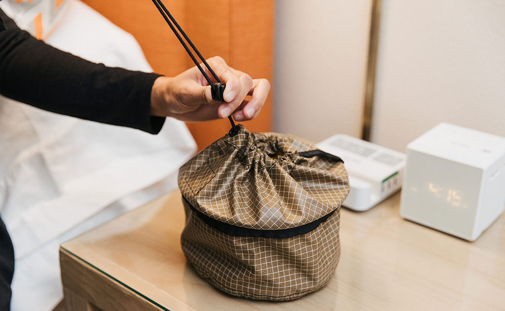 lifestyle visible^^A person sliding the locking slider down to seal closed a Travel Tray.