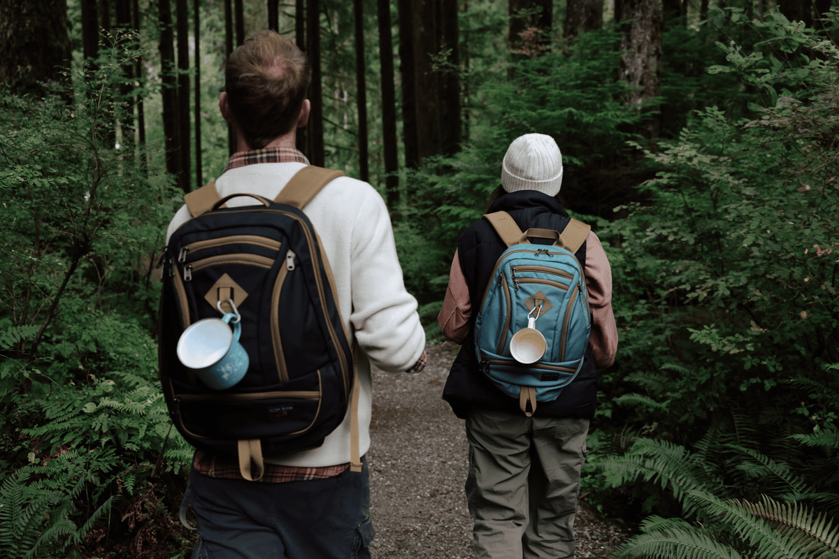 One person wearing a Guide's Edition Synik 30 and another person wearing a Guide's Edition Synapse 19 walking along a hiking trail.