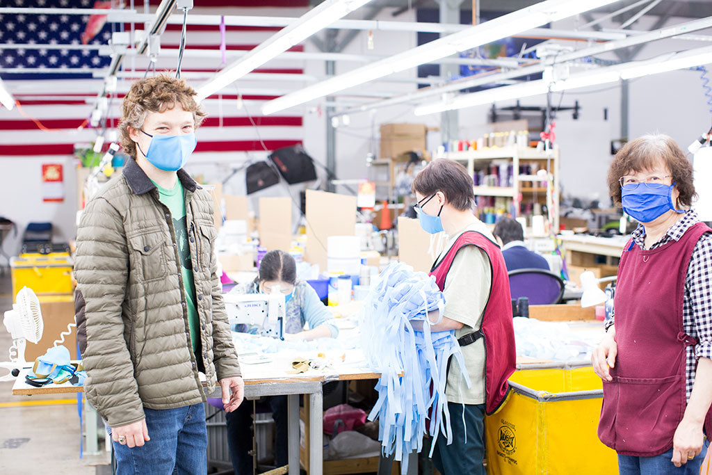 TOM BIHN crew members wearing and sewing cloth masks.