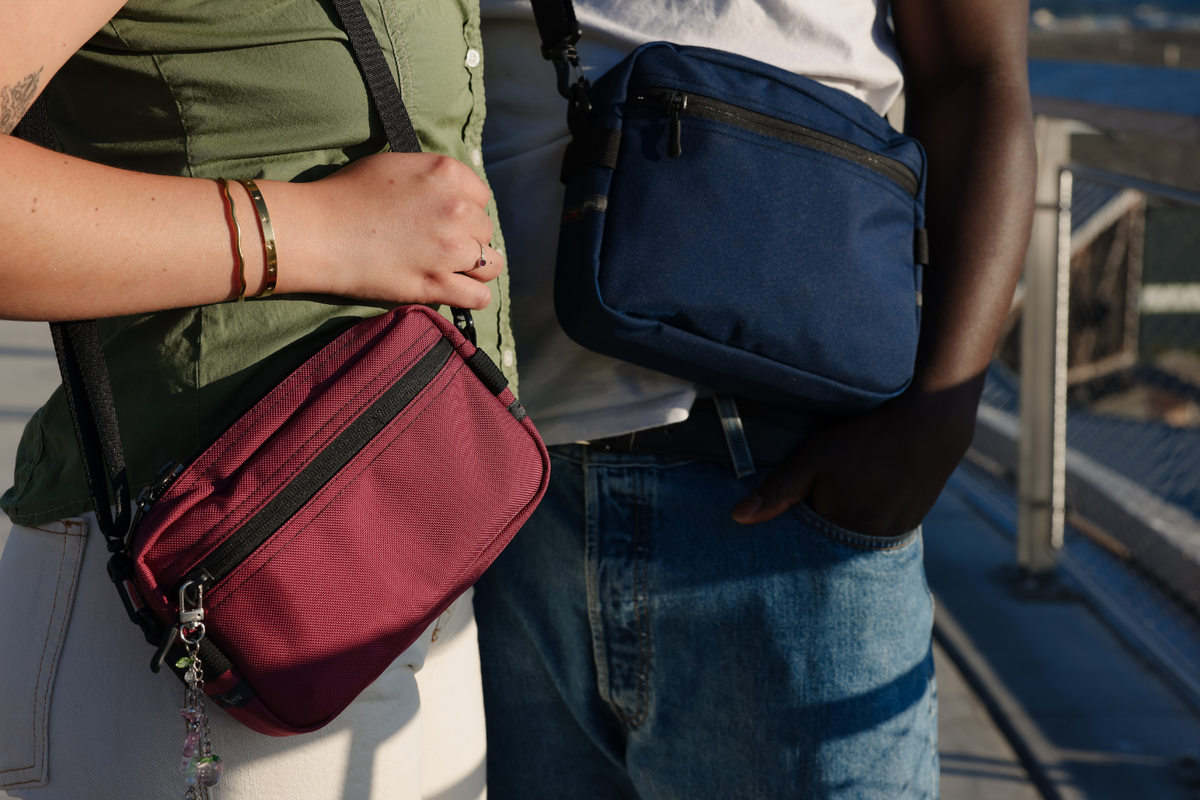 Close up of a Raspberry Side Effect and a Deep Blue Side Kick worn crossbody by two people. 