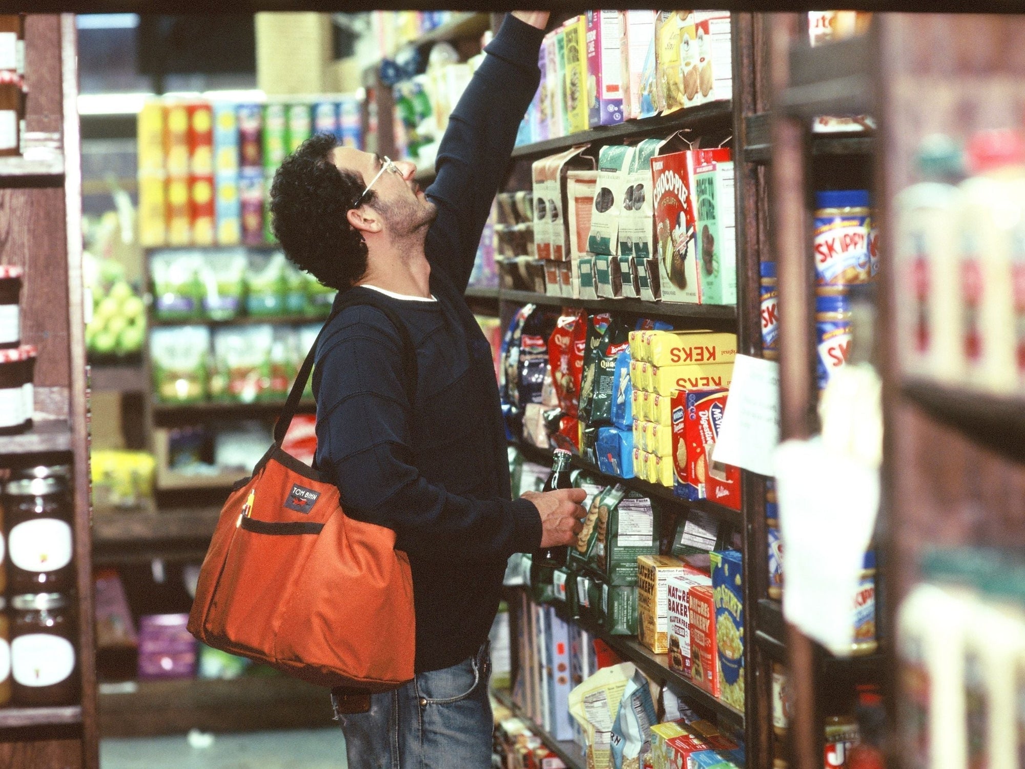 Person carrying Truck over their shoulder shopping in a grocery store.