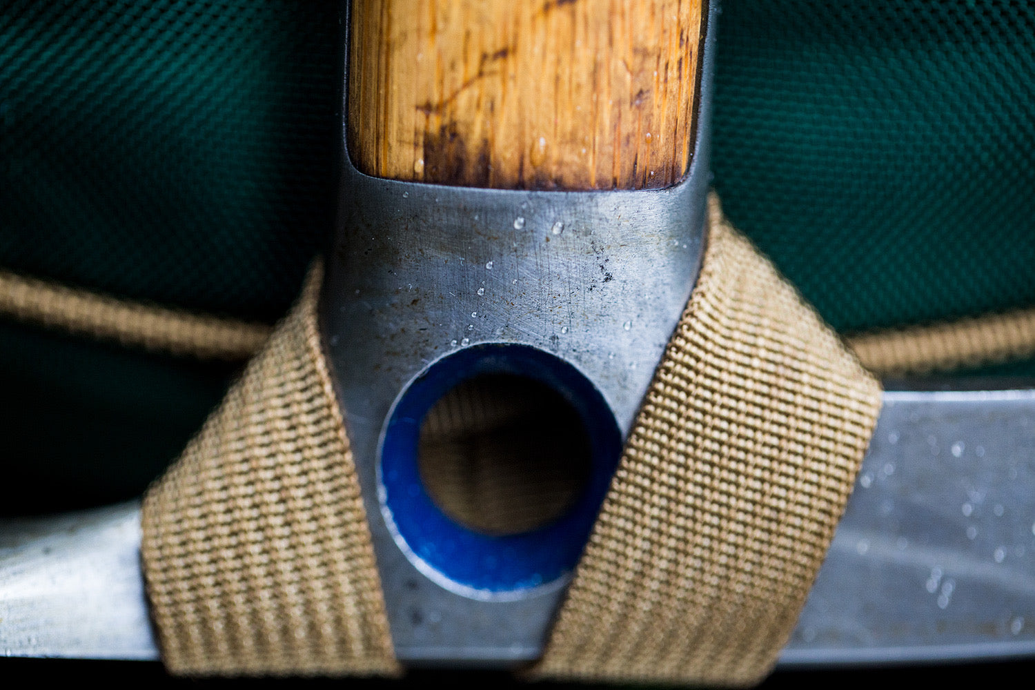 A close up of an ice axe  being held by an ice axe loop.
