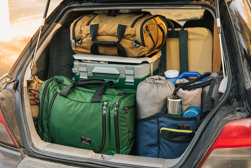 The back of a hatchback car, packed with two Aeronauts, a Monster Truck and other camping gear.