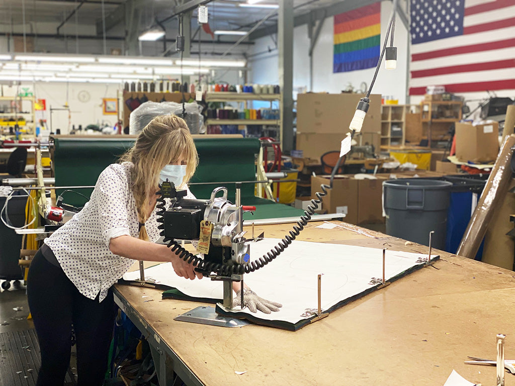 A person cutting fabric at the TOM BIHN factory.