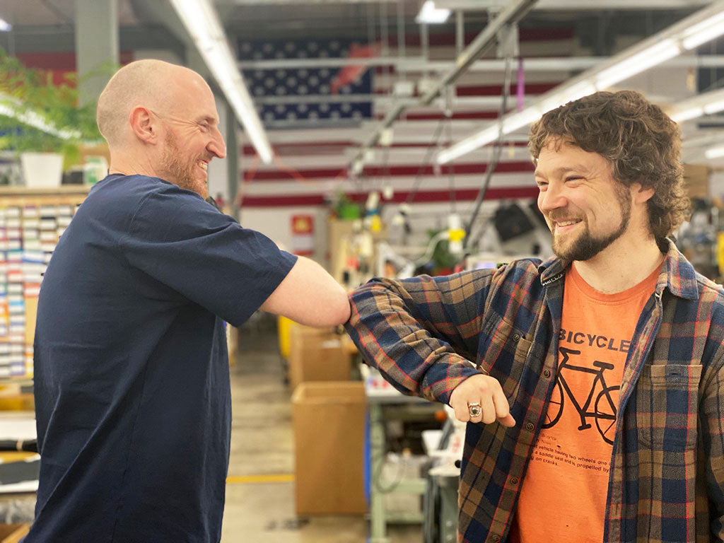 Two people doing an 'elbow bump' instead of a fist bump.