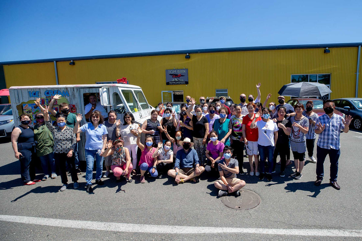 A group photo of TOM BIHN crew outside of their factory, enjoying ice cream in front of an ice cream truck.