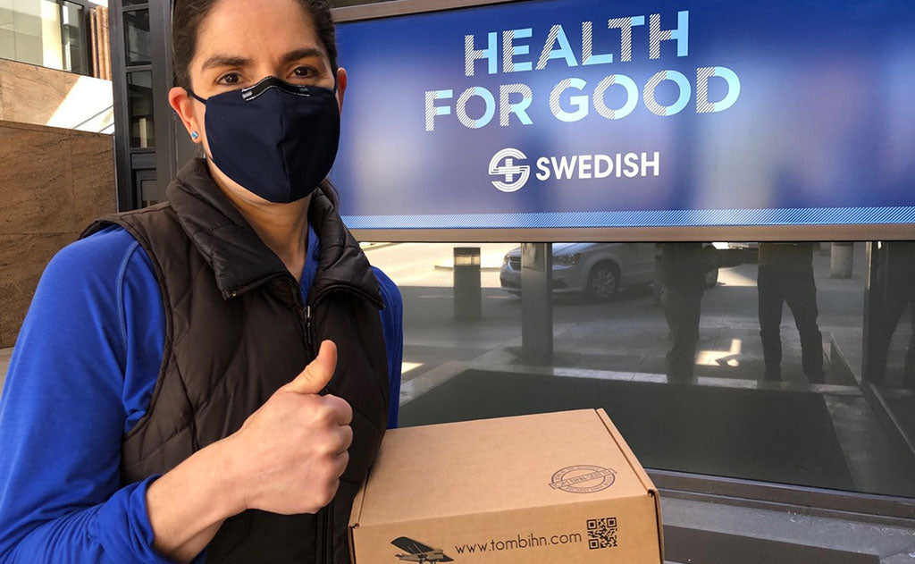 A person in a TOM BIHN Face Mask giving a thumbs up.