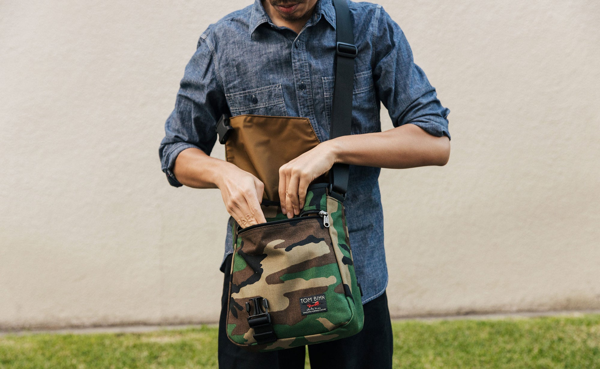 A person wearing a Beaver Camo Medium Cafe Bag.