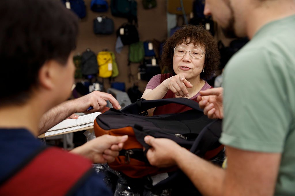 TOM BIHN crew examining and discussing the back of a Synik backpack.