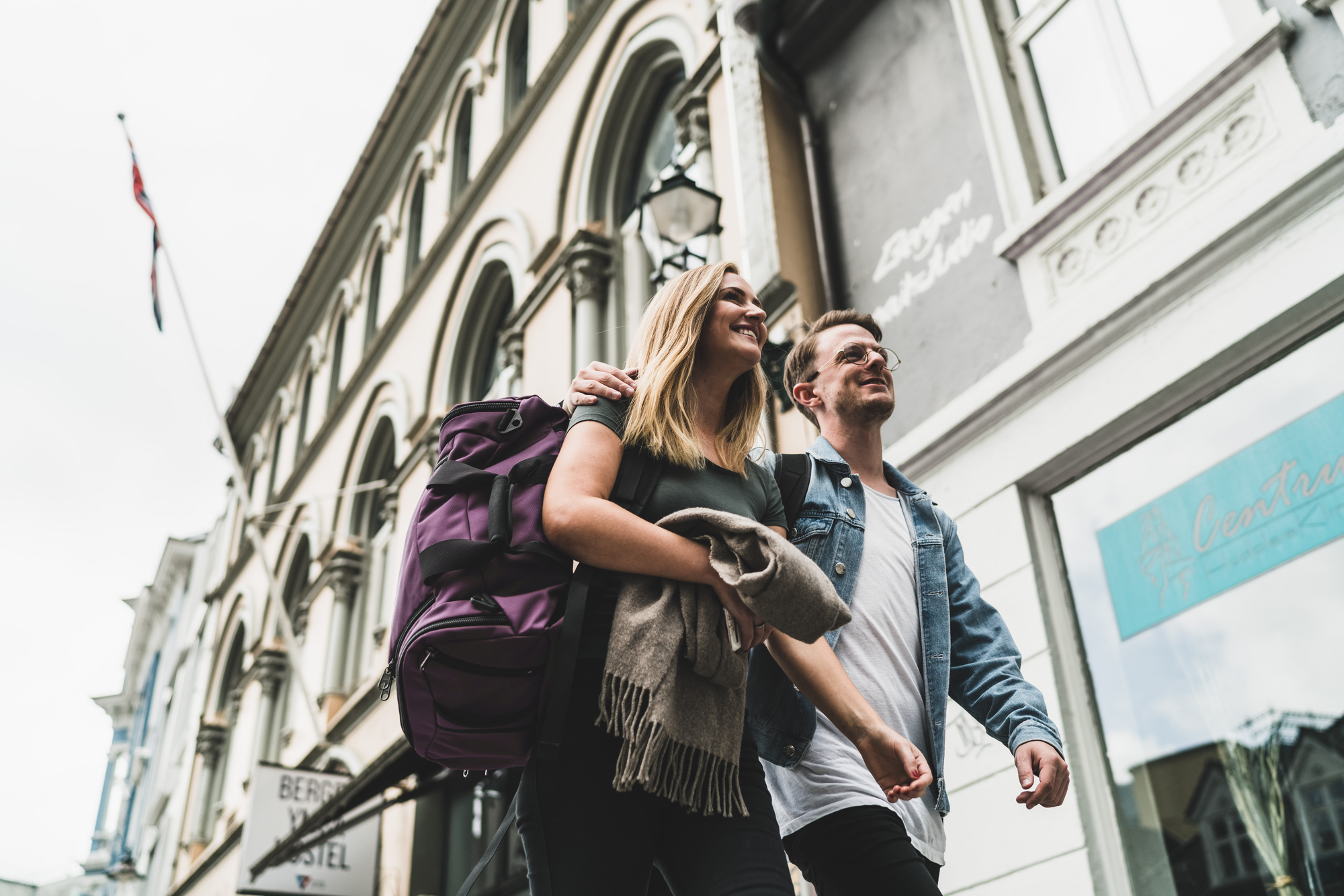 A couple walks through Paris, they are both wearing Aeronaut 30s, one in Aubergine, the other in Black,
