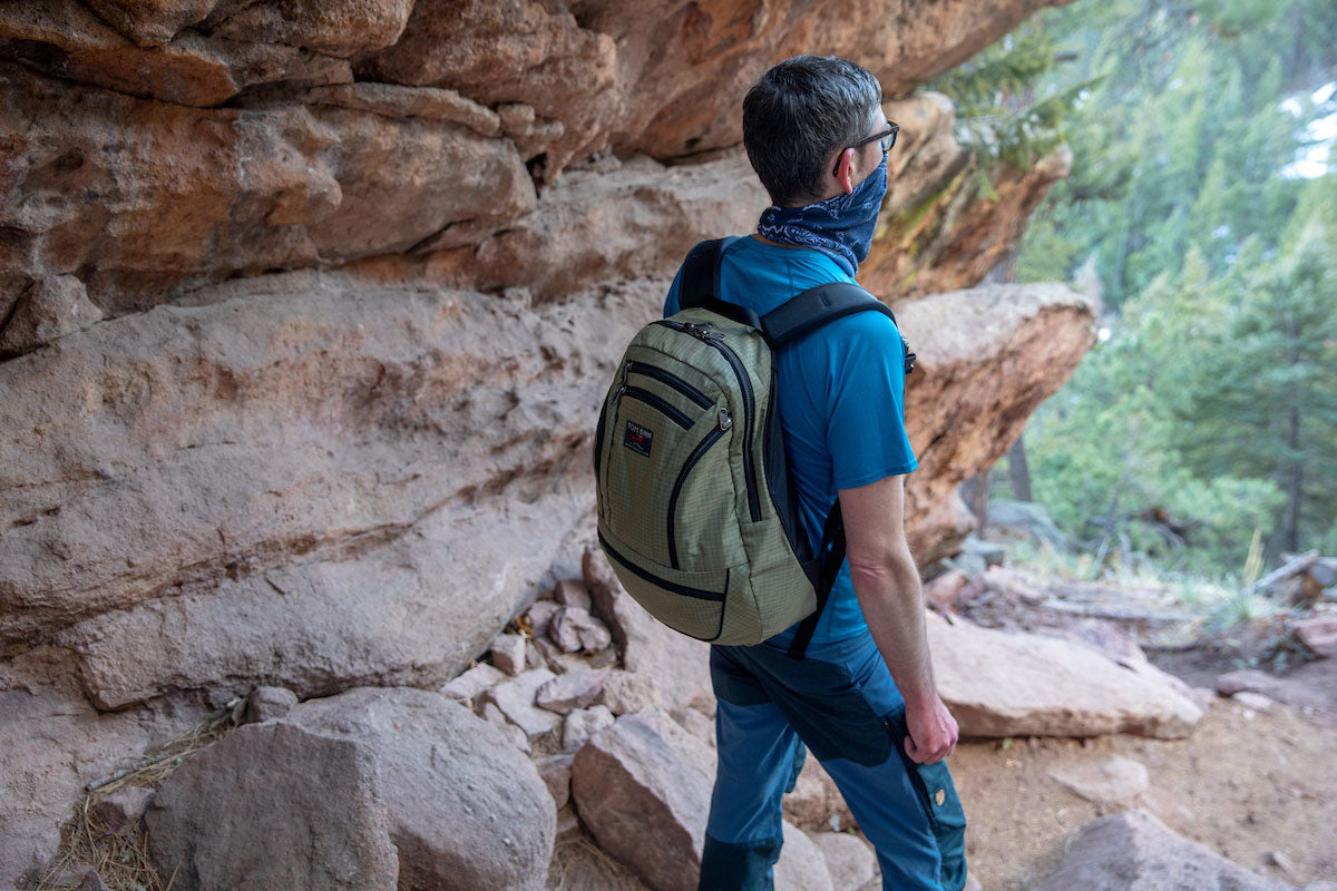 A person hiking, wearing the Synapse 25 backpack.