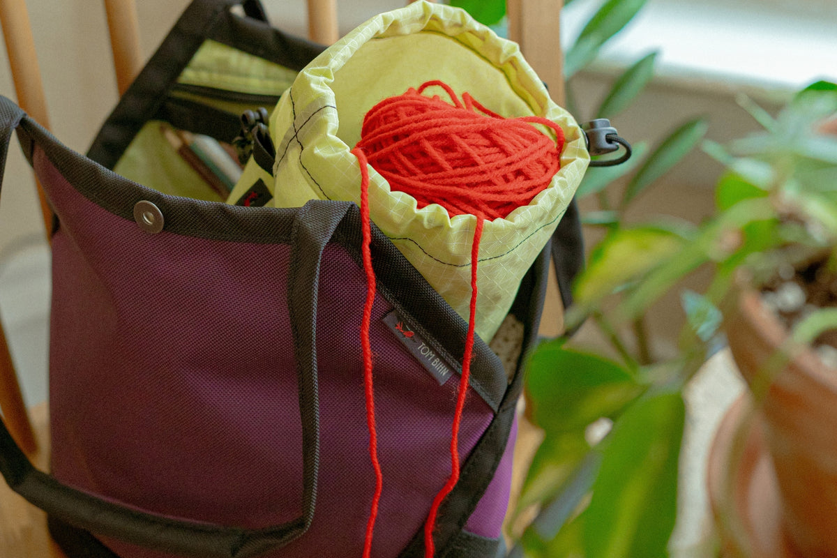 lifestyle visible^^A Little Swift sitting on a chair with yarn spilling out of Yarn Stuff Sack.