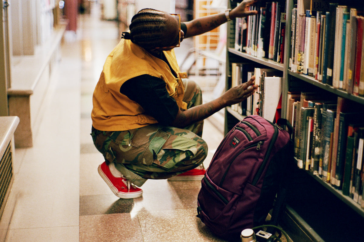 lifestyle visible^^Person selecting books wiht Synapse 25 by their side.
