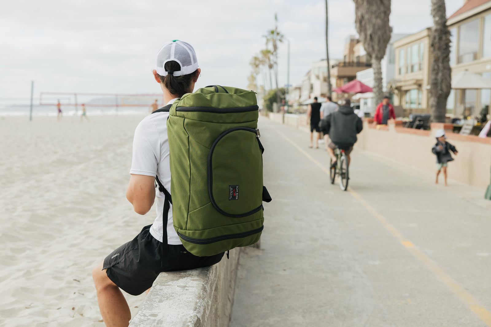 lifestyle visible^^Person carrying an Aeronaut 45 sitting on the wall at the Venice Beach, CA boardwalk.