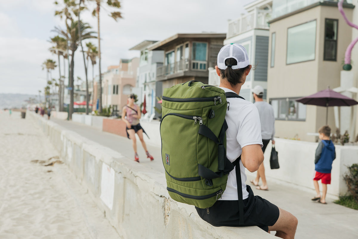 lifestyle visible^^Person carrying an Aeronaut 45 sitting on the wall at the Venice Beach, CA boardwalk.