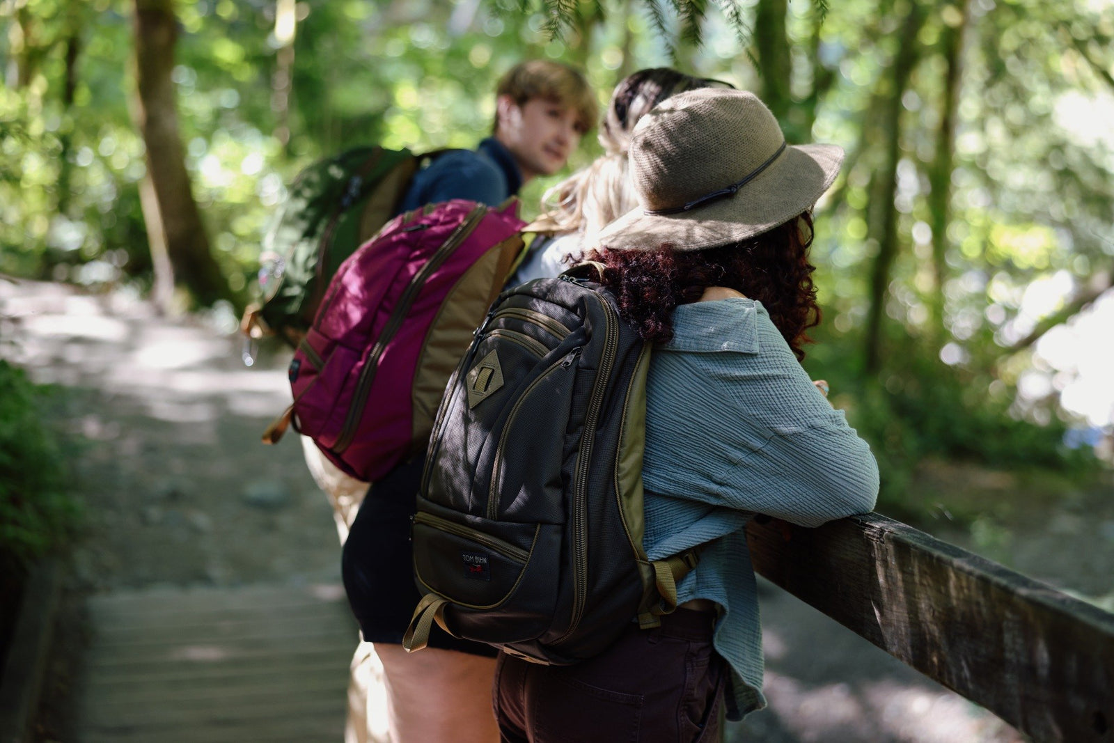 lifestyle visible^^a group hiking carrying Guide's Edition Synik 26 in Ursa Brown, Raspberry pink, and a Saguaro green