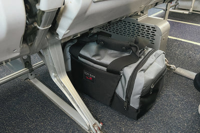 visible lifestyle^^Night Flight Travel Duffel under the seat lengthwise on a plane.