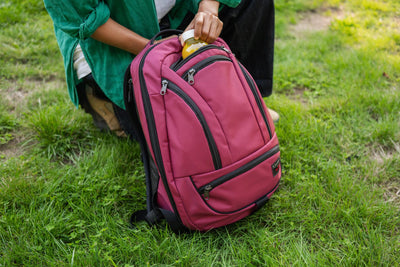 visible lifestyle^^A person retrieving a drink from the Synik 26 water bottle pocket