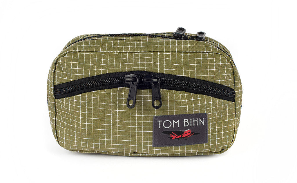 visible variant TB0418-8D^^The front of a Handy Little Thing #1 in Taiga (olive green with white grid) 200 Halcyon showing the front zipper with two slider and logo at the bottom-right corner.