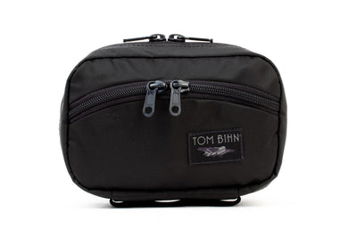 visible variant TB0418-BJ^^The front of a Handy Little Thing #1 in Black 210 Ballistic showing the front zipper with two slider and logo at the bottom-right corner.