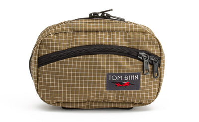 visible variant TB0418-CD^^The front of a Handy Little Thing #1 in Coyote (tan with white grid) 200 Halcyon showing the front zipper with two slider and logo at the bottom-right corner.