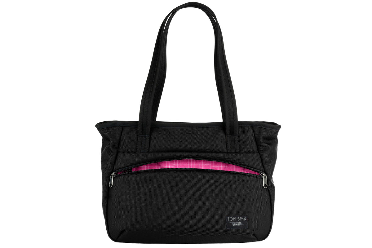 visible variant TB0715-BKPD^^Photo of the Nomad Tote in Black Ballistic with Cerise (pink with white grid) 200 Halcyon interior.