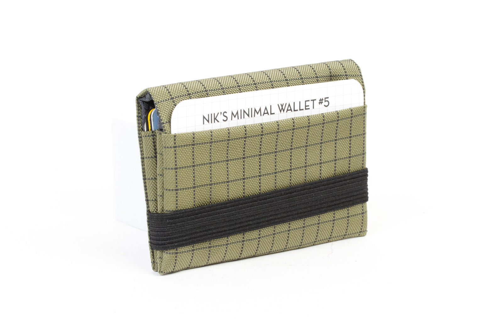 visible variant TB1275-VH^^The Size 5 Nik's Minimalist Wallet in Taiga (olive green with grey grid) 400 Halcyon closed with the attached elastic band.