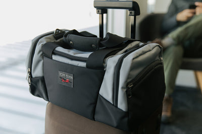 visible lifestyle^^Night Flight Travel Duffel on top of a roll-aboard suitcase.