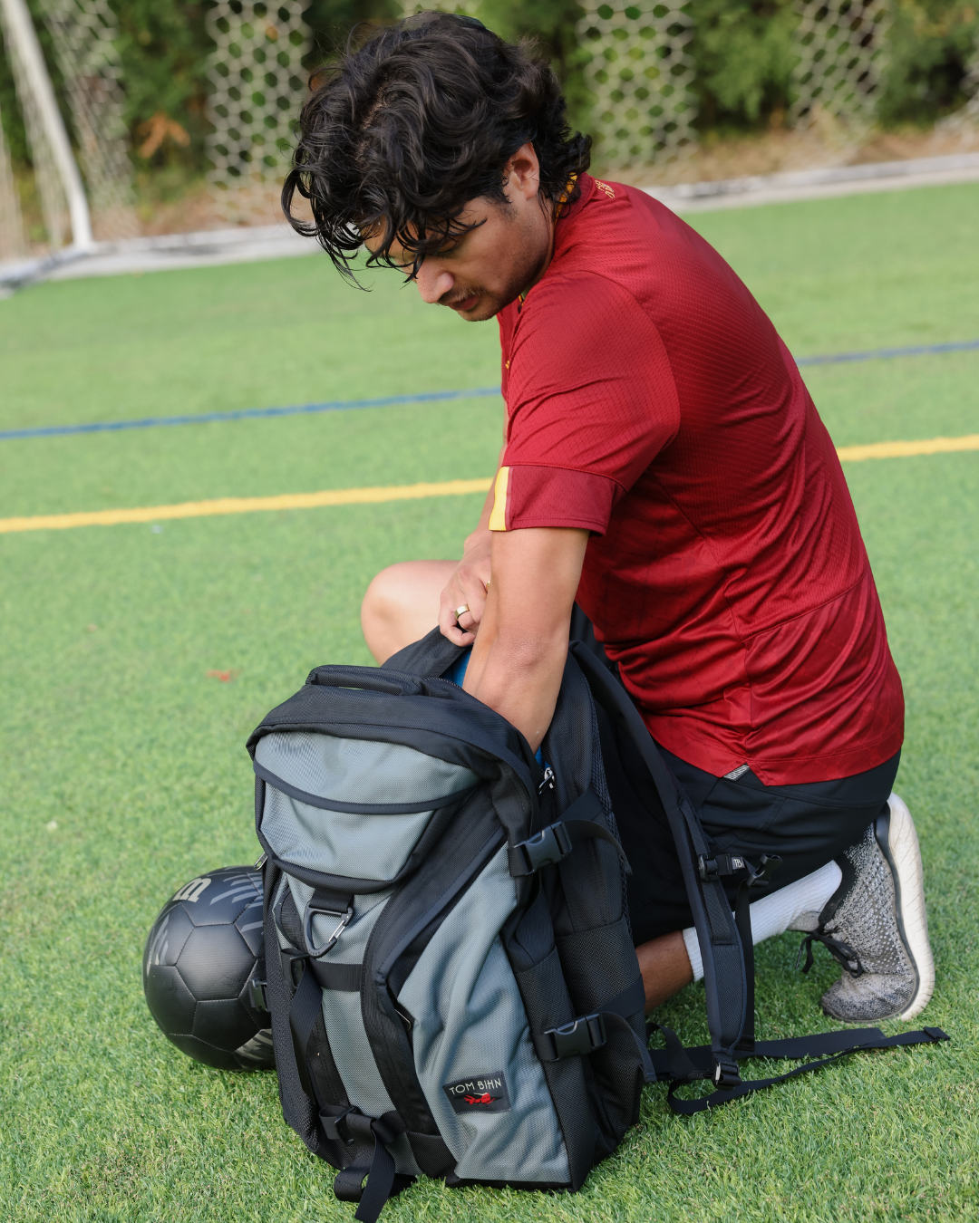 lifestyle visible^^A person reaching into the main compartment of Brain Bag.
