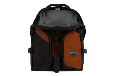 visible variant TB0114-TKGL^^The Brain Bag in Burnt Orange Ballistic with the front main compartment zipper opened to reveal its Mountain Grey (grey with light grey grid) 210 Cerylon interior.