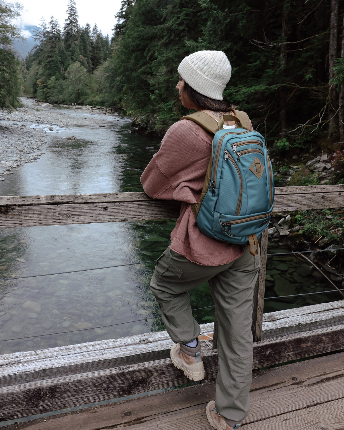 visible lifestyle^^A person carrying a GE Synapse 19 looking over a river on a bridge