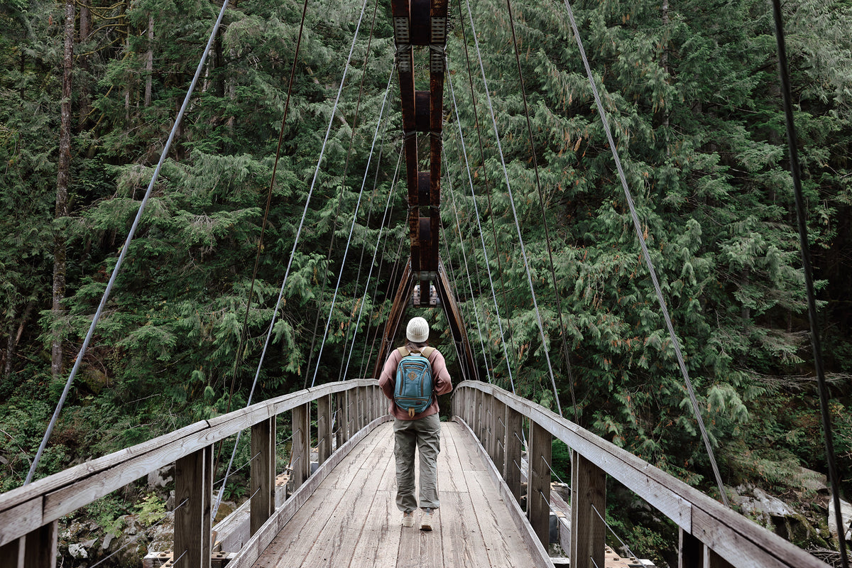 visible lifestyle^^A person carrying a GE Synapse 19 on a suspension bridge